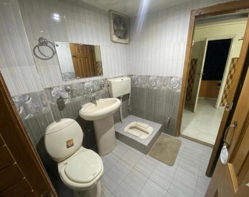 a bathroom with a toilet and a sink at Redapple Rooms in Murree