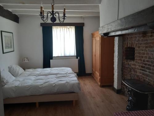 a bedroom with a bed and a brick fireplace at Stegelshof 1 in Eygelshoven