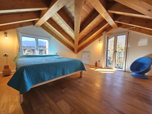 a bedroom with a bed and a blue chair at I LAGHEE casette BREVA e TIVANO Lakeside Garden Bike&Boat&Scooter Lake Como in Colico