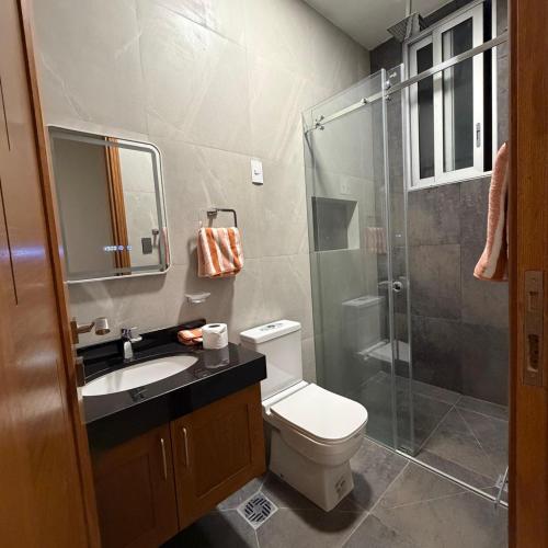 a bathroom with a toilet and a glass shower at Plaza Central Boutique House in Cochabamba