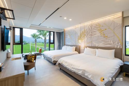 a hotel room with two beds and a television at 亮Villa in Sanxing