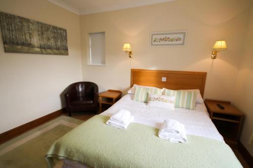 a bedroom with a bed with two towels on it at Llety Ceiro Guesthouse in Aberystwyth