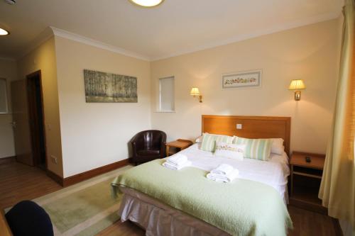 a hotel room with a bed and a chair at Llety Ceiro Guesthouse in Aberystwyth