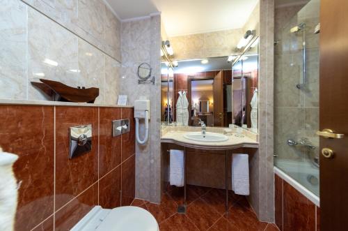 a bathroom with a sink and a toilet and a tub at Helena Park - Ultra All Inclusive in Sunny Beach