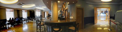 a restaurant with a bar and tables and chairs at Cumbria Spa Hotel 3* Sup in Ciudad Real