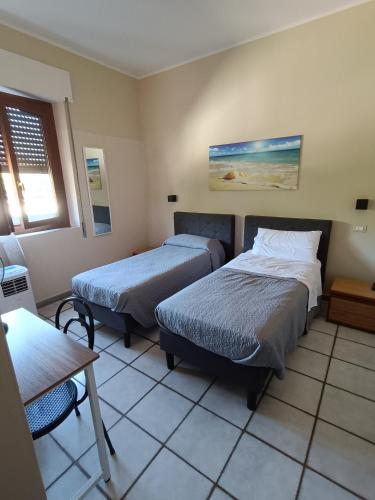 a bedroom with two beds and a table and a table at Maurin in Carrara