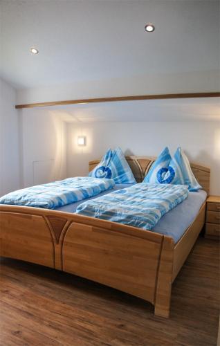 a bed with blue pillows on it in a room at Ferienwohnungen Perterer in Fieberbrunn