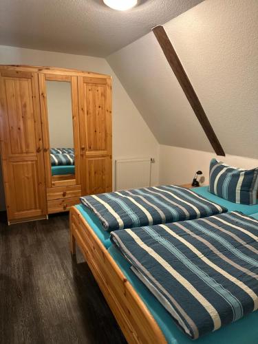 a bedroom with two beds and a wooden cabinet at Hof Döttgebüll in Aventoft