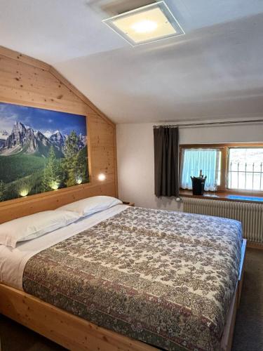 a bedroom with a bed with a painting on the wall at Chalet Monte Coston in Lastebasse