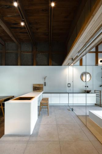 a kitchen with white counters and a wooden ceiling at 一乗谷 朔 saku in Fukui