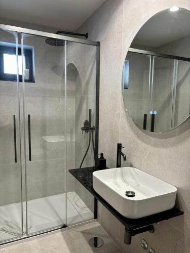 a bathroom with a sink and a shower and a mirror at Vila Hotel By VimaHotels in Guimarães