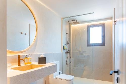 a bathroom with a sink and a toilet and a mirror at Canyamel Sun Suites Hotel in Canyamel