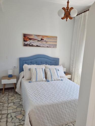 a bed with a blue headboard in a bedroom at O Curro de Arou in Arou