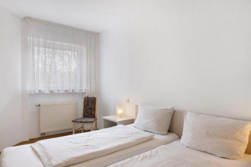 a white bedroom with two beds and a window at Parkblick Doppelzimmer 26, 29 in Bad Dürrheim