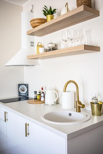 a kitchen counter with a sink and shelves at Järvevaatega studio apartment in Viljandi
