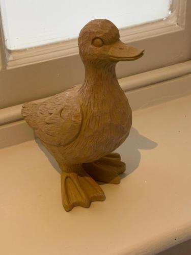 a wooden duck statue sitting next to a window at Apartment No.1 in Lincoln
