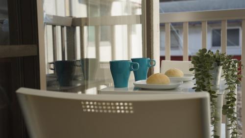 a table with plates of food and cups on a window at Rabbit Island Inn in Mihara