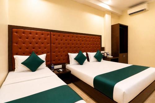a hotel room with two beds and a headboard at Hotel BKC Suite in Mumbai