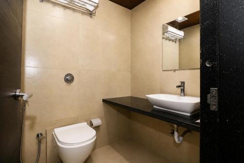 a bathroom with a white toilet and a sink at Hotel BKC Suite in Mumbai