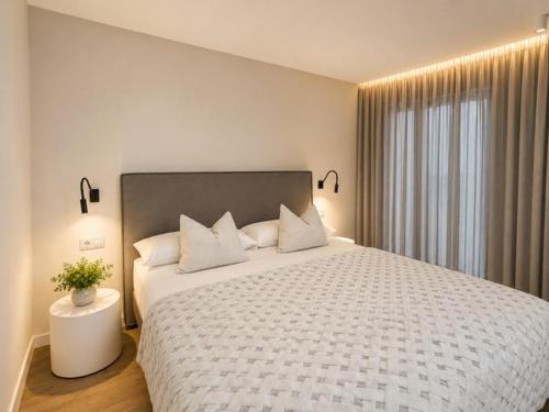 a bedroom with a large bed with a white comforter at Apartaments Turístics Conseller in Andorra la Vella
