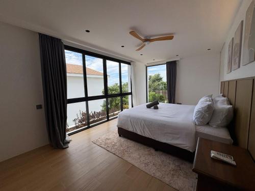 a bedroom with a bed and a large window at Villa 7 Ocean View Pool Villa in Bophut