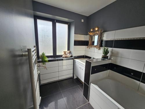 a bathroom with a large tub and a window at Superbe appartement 2 a 6 pers. hyper cocooning in Gérardmer