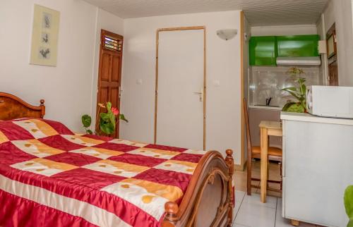 a bedroom with a bed with a checkered comforter at Studio Anse L'Etang in Tartane