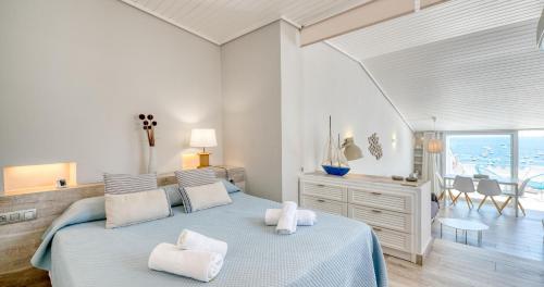 a bedroom with a blue bed with white pillows at Exclusive Position Front Line Apartments Calau in Calella de Palafrugell