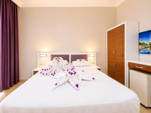 ein Hotelzimmer mit einem Bett, auf dem Handtücher liegen in der Unterkunft Saygili beach hotel in Side
