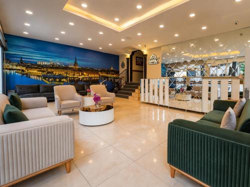Eine Lobby mit Sofas und Sesseln und einem Gemälde eines Hafens in der Unterkunft Saygili beach hotel in Side