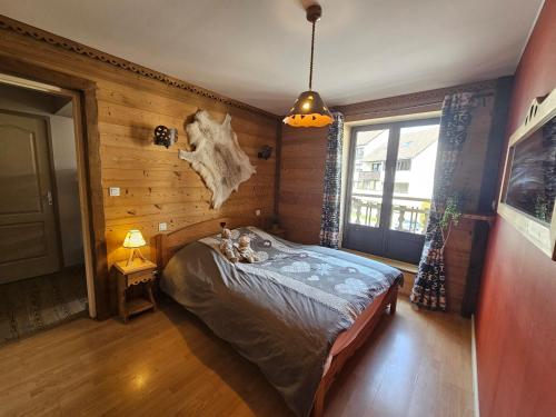 a bedroom with a bed in a room with wooden walls at Superbe appartement 2 a 6 pers. hyper cocooning in Gérardmer
