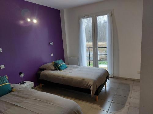 a bedroom with two beds and a purple wall at Pavilion - T3 Duplex, avec Terrasse et Parking in Montagnat