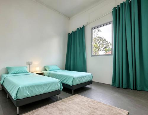 two beds in a room with green curtains at D'Monochrome in Singapore