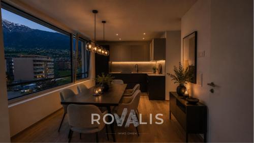 a dining room with a table and chairs and a kitchen at Brig Panorama Spa in Brig