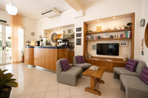 a living room with two chairs and a television at Hotel Villa Gioiosa - Beach & Bistrot in Rimini