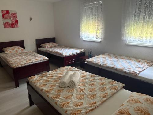 three beds in a room with windows at Una Serenity Villa in Bare