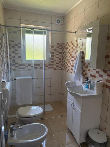 a bathroom with a toilet and a sink and a shower at Una Serenity Villa in Bare