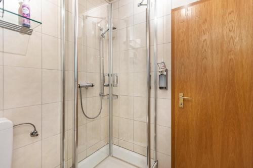 a shower with a glass door in a bathroom at Ferienhaus Rothaarblick mit Sauna in Schmallenberg