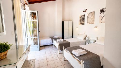 a hotel room with two beds and a table at Villa Amy in Achladies