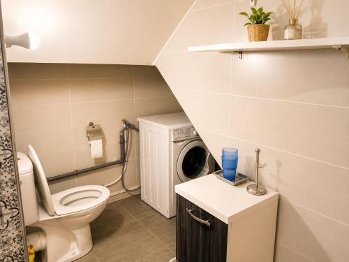 a bathroom with a toilet and a washing machine at House Soleil in Agadir nʼ Aït Sa