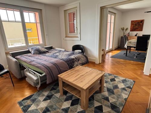 a bedroom with a bed and a table in it at Chez Carole (4 pièces) in Neuchâtel
