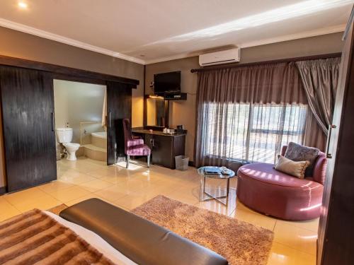 a large living room with a couch and a chair at Altissimo Guesthouse in Bloemfontein