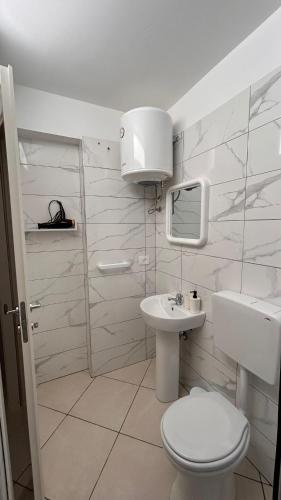 a white bathroom with a toilet and a sink at La camera a Lido Burrone in Favignana