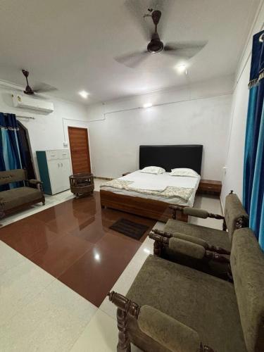 a room with a bed and a couch in it at Trivrindam Hotel in Gorakhpur