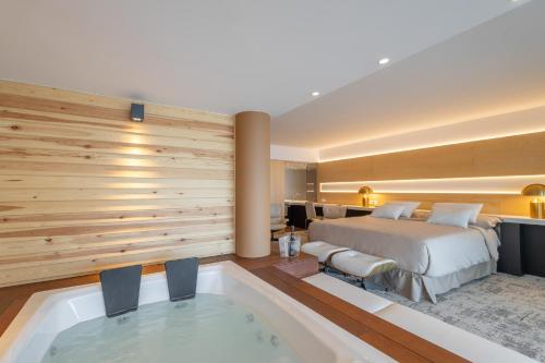 a hotel room with a bed and a bath tub at Sitges Suites - Premium in Sitges