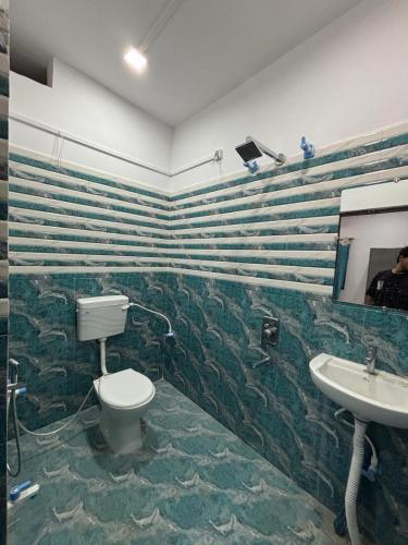a bathroom with a toilet and a sink at Trivrindam Hotel in Gorakhpur
