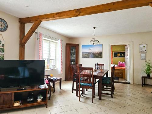 a living room with a television and a dining room at hundefreundliches Ferienhaus in Kröslin