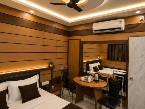 a bedroom with a bed and a desk and a table at Orbit guest house by Flying Suites in Kolkata
