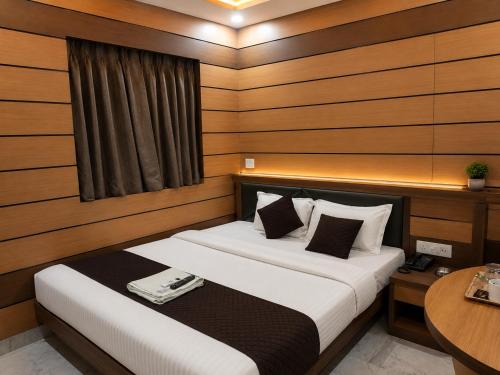 a bedroom with a bed and a table in it at Orbit guest house by Flying Suites in Kolkata