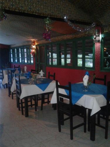 a dining room with tables and chairs in a restaurant at Eco-Lodge Hotel Oasis Fishing in Saint-Louis